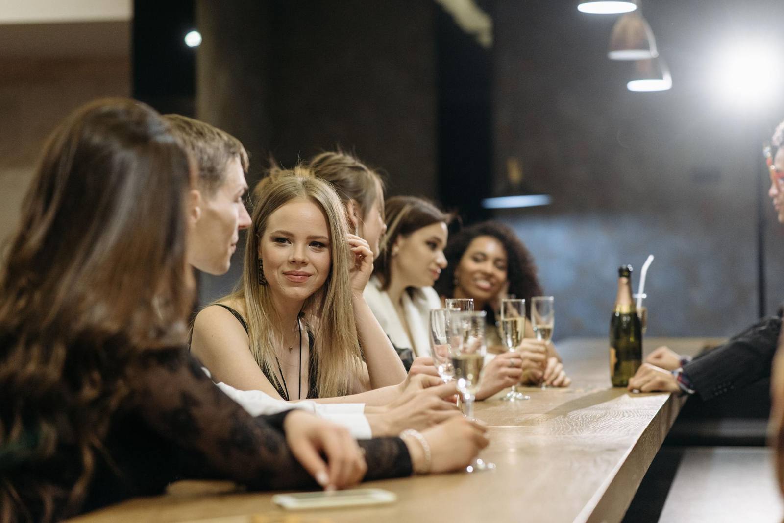 Gäster som minglar vid en bar med glas bubbel i handen under en kväll ute på stan